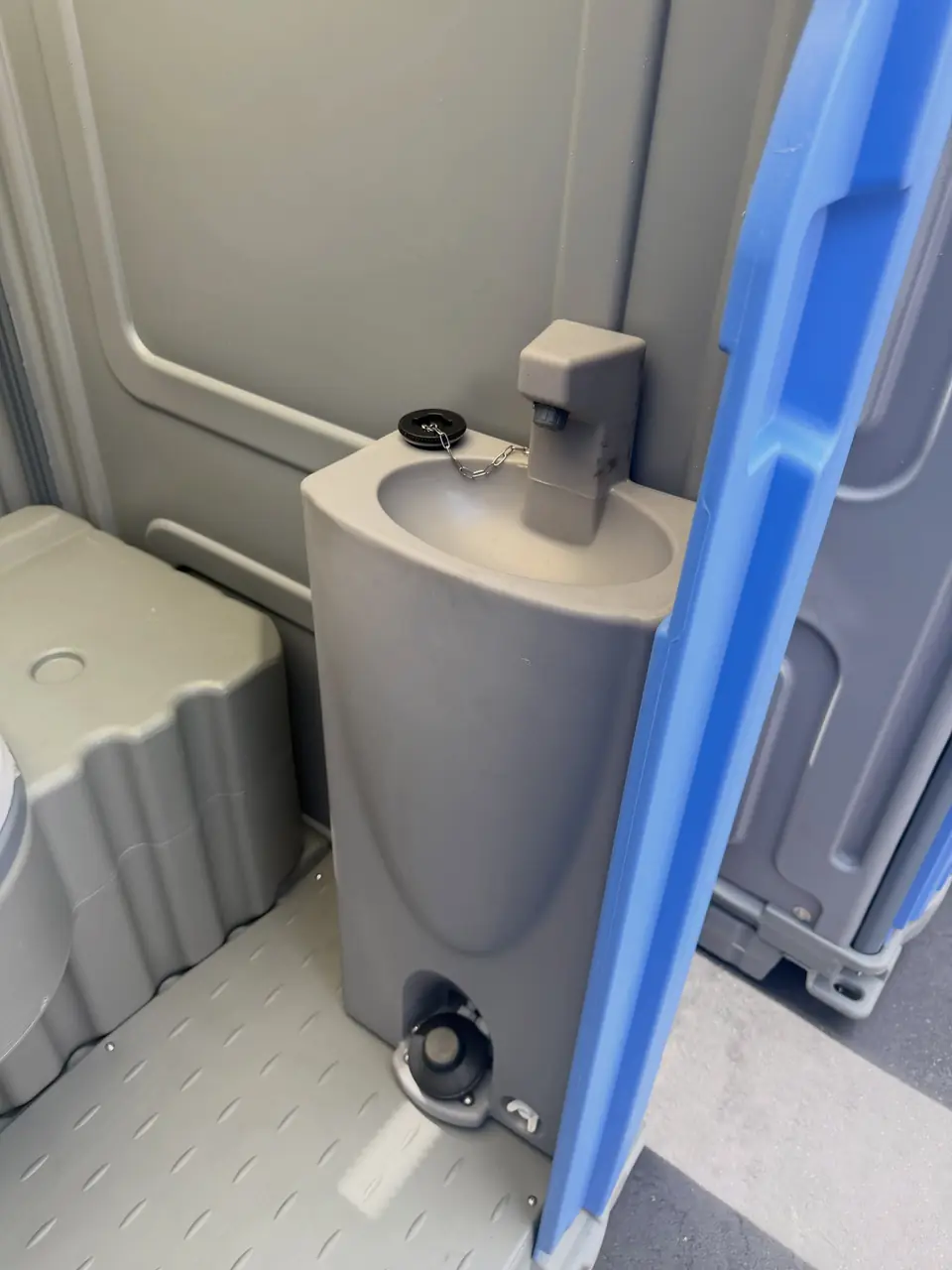Foot-pump hand sink inside a deluxe portable toilet